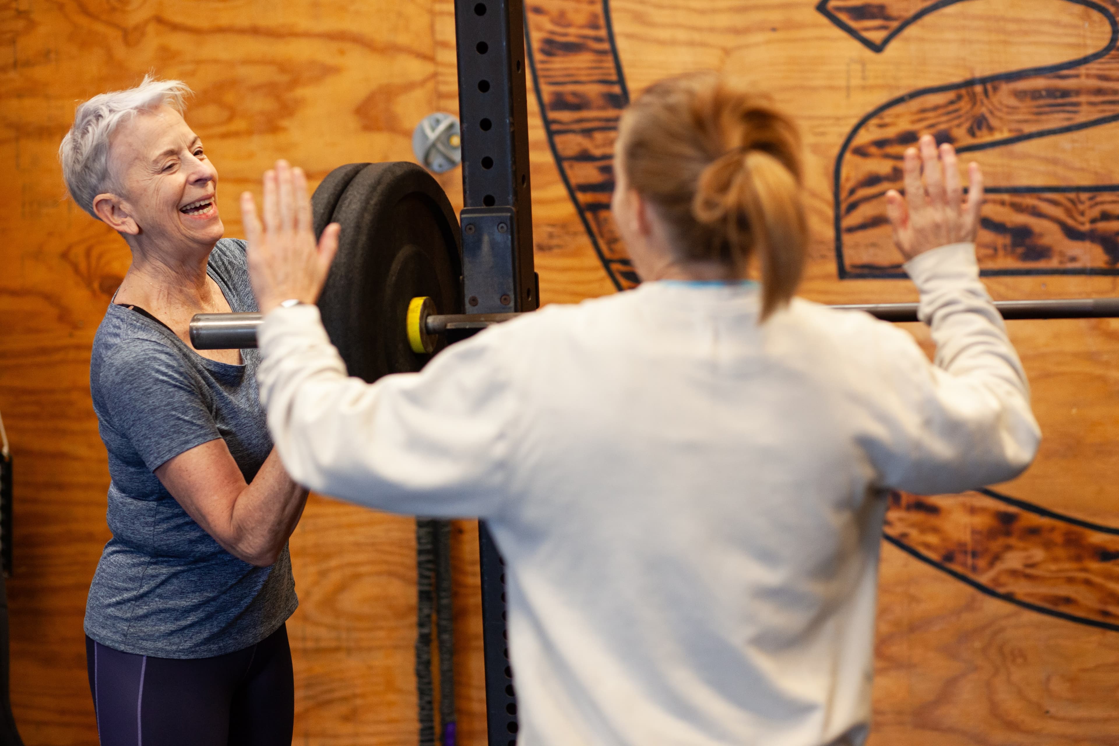 Members high-fiving in front of the 2020FIT logo wall